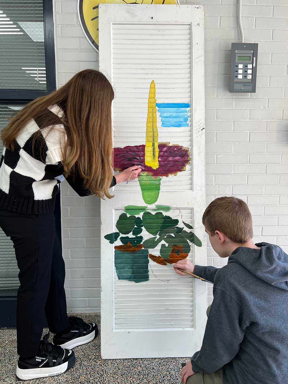 Art Students painting a door for “Opening Doorways to Spring” Exhibit
